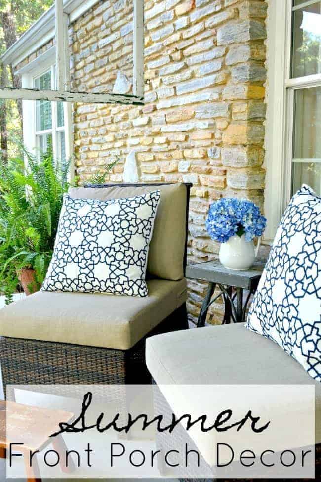 two wicker chairs on covered porch with blue and white pillows, a little footstool and a hanging screen window