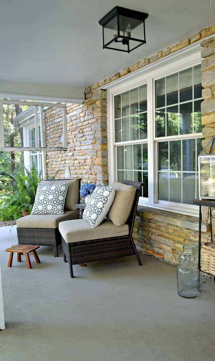 covered front porch with 2 wicker chairs and blue and white pillows