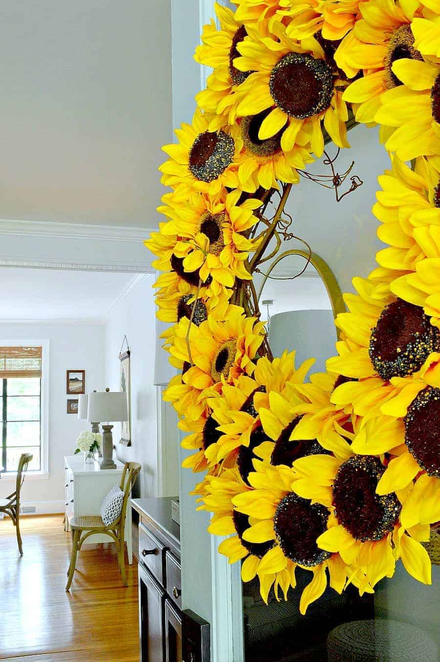 sunflower wreath hanging on turquoise front door with a view into a house