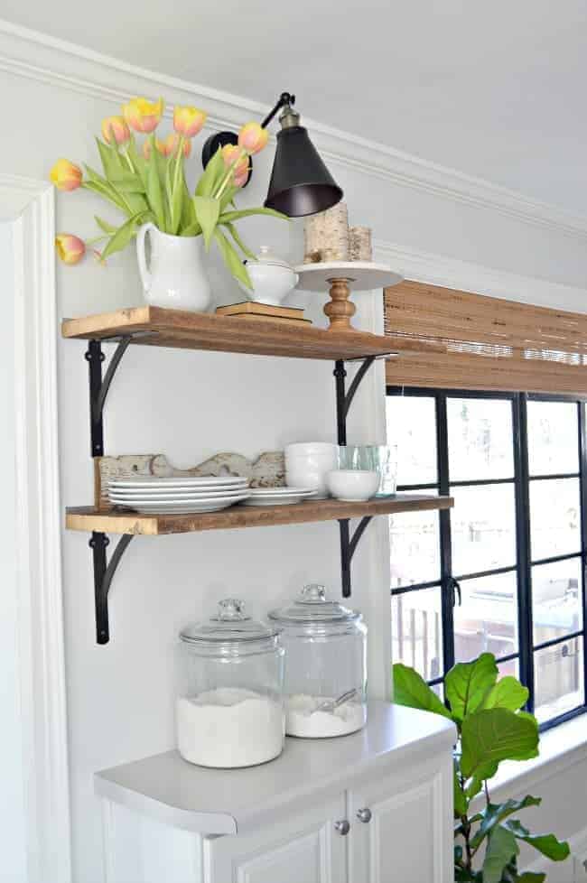 How to Make a DIY Wireless Wall Sconce Shelf Photo DIY wireless wall sconce hanging over open shelving in kitchen with a pitcher of tulips on top shelf
