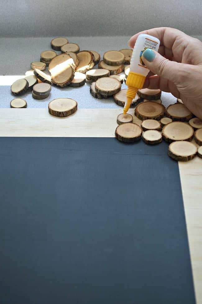 using Gorilla Glue to glue a wood round on a rustic wood slice chalkboard