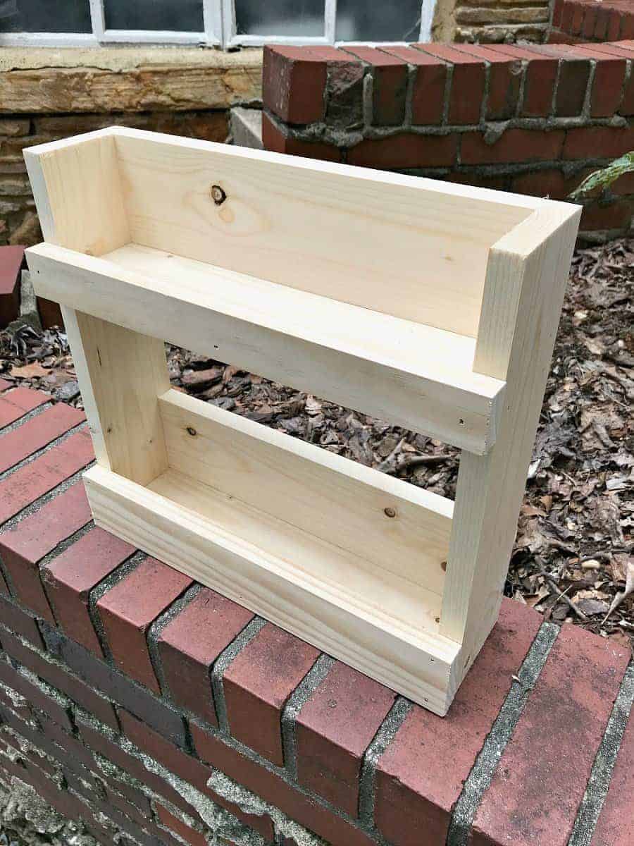 completed wall mounted coat rack with shelves sitting on brick wall