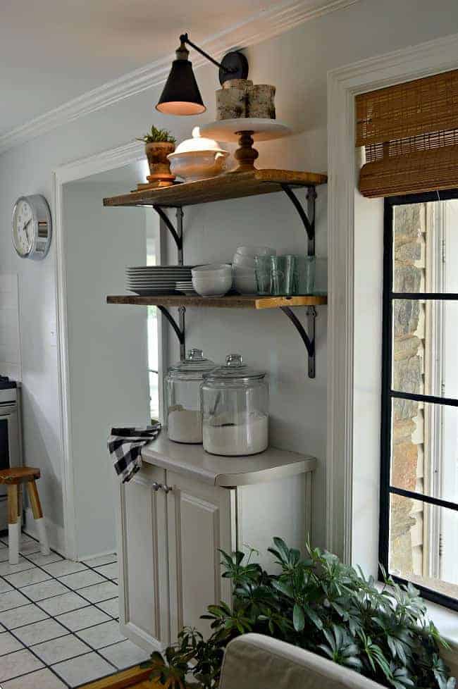 How to Make a DIY Wireless Wall Sconce Dusk Photo dusk with a lighted DIY wireless wall sconce hanging over open shelving in kitchen
