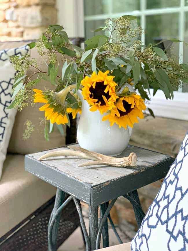 pitcher of sunflower and eucalyptus on old wooden table