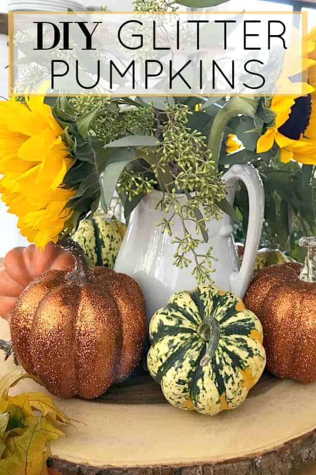 pitcher of sunflowers with glitter pumpkins in front