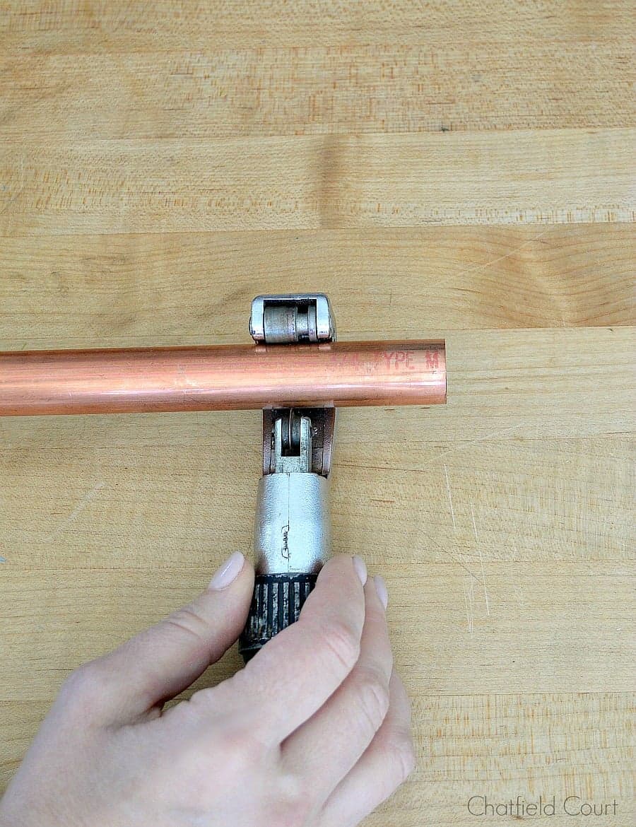 cutting a copper pipe with a pipe cutter