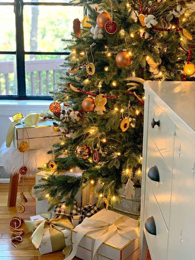 A Rustic Christmas Tree with white Christmas gift boxes tied with ribbon