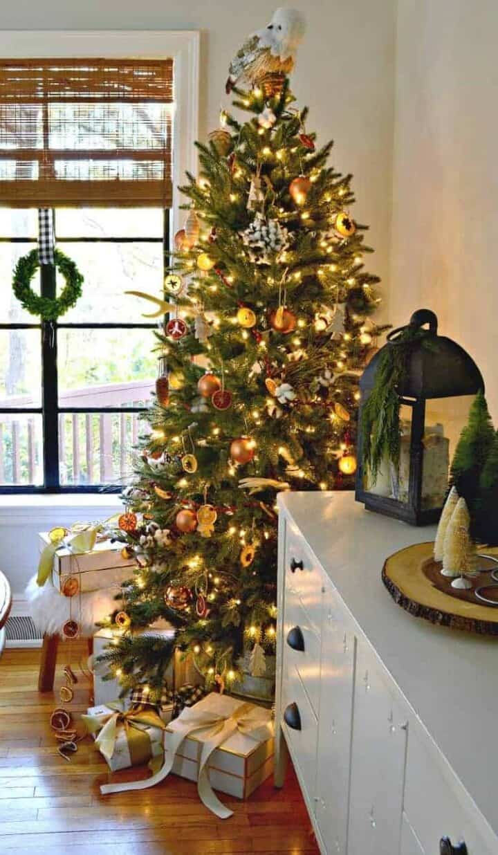 A Cozy Christmas Cottage dining room with a nature inspired Christmas tree in the corner by the window