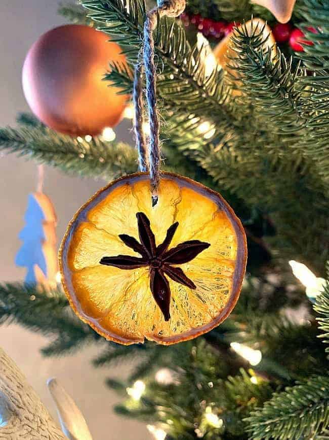 DIY dried orange slice ornaments with star anise hanging on Christmas tree