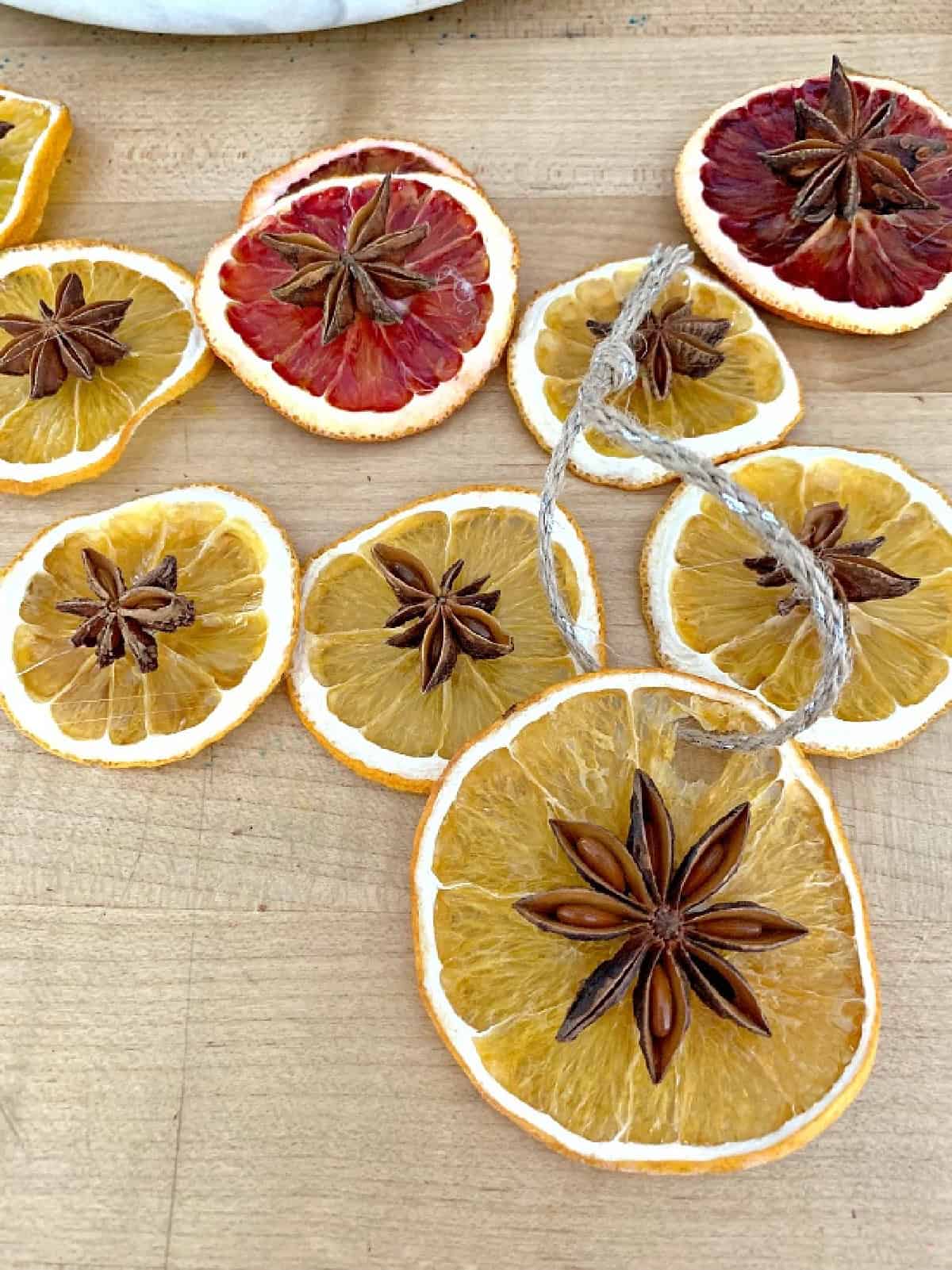 DIY Dried Orange Slice Ornaments with star anise star anise and dried orange slice ornaments laying on cutting board