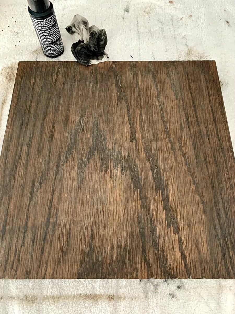 piece of oak wood after black paint is applied over stain