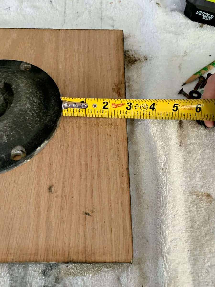 measuring bracket on oak wood with a tape measure