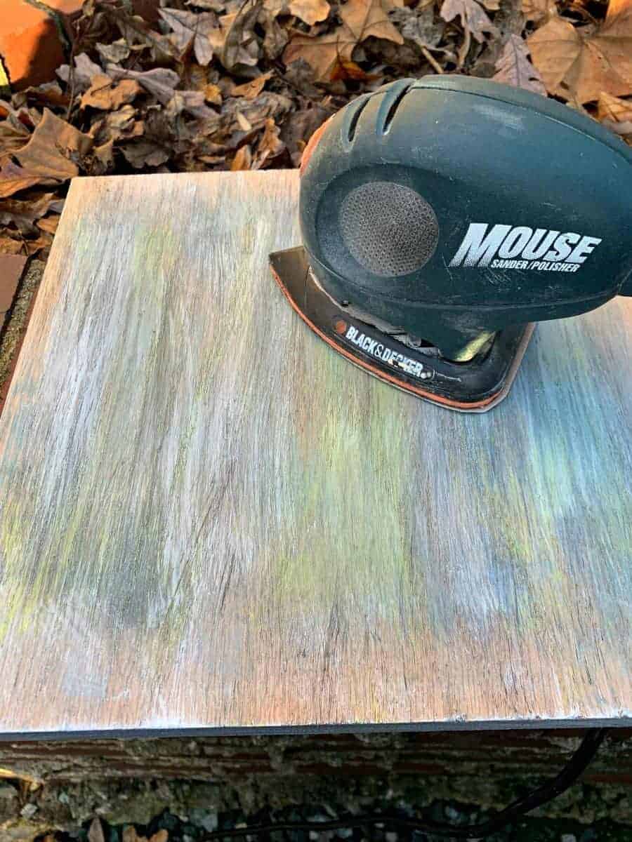 palm sander on top of piece of oak wood