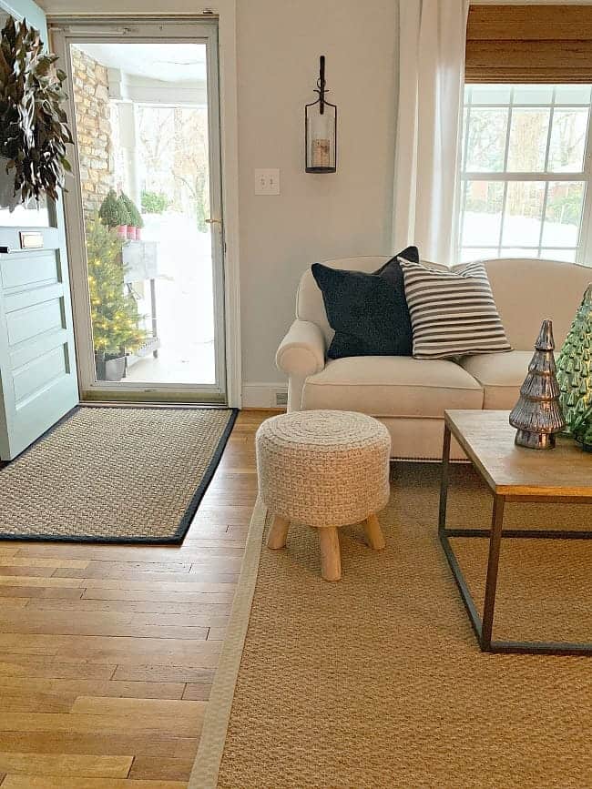 front door and white living room sofa with striped pillow