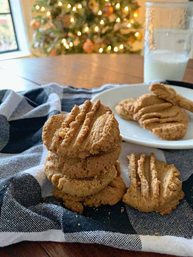 4 cookies stacked on top of each other on a black and white cloth napkin for this easy flourless peanut butter cookie recipe