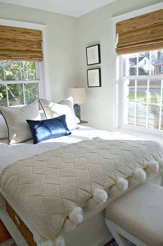 platform bed with textured throw and woven shades in window for guest bedroom makeover 