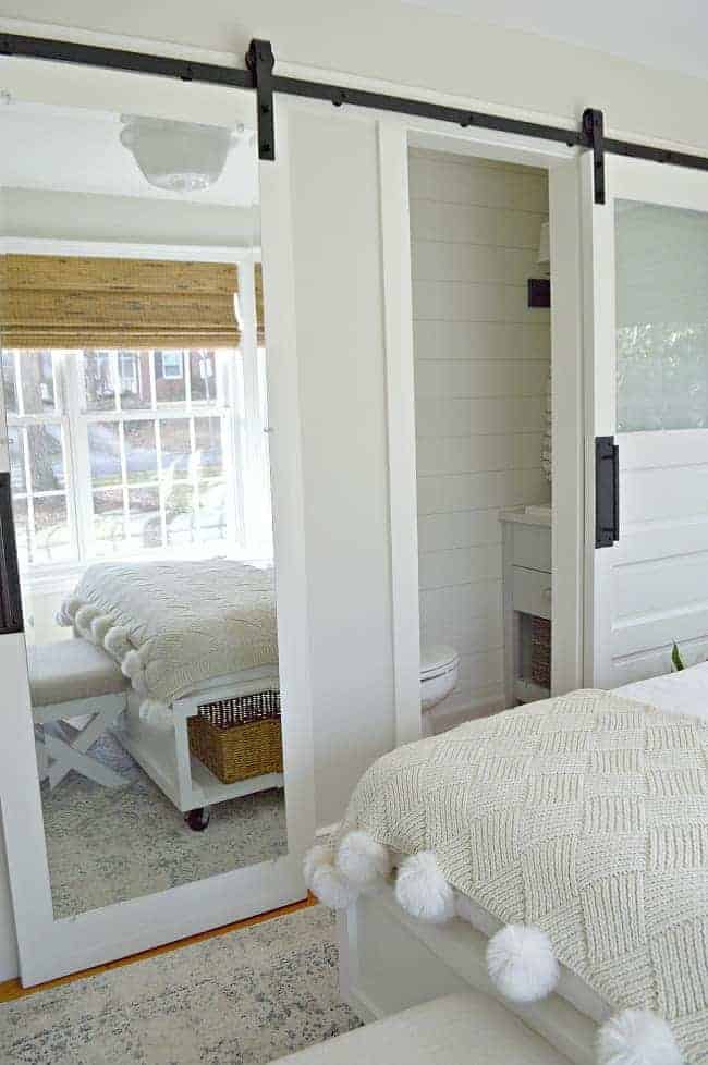 view of sliding barn doors on closet and powder room for guest bedroom decorating makeover