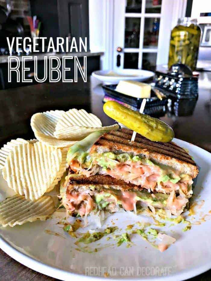 vegetarian reuben on plate with pickle and chips