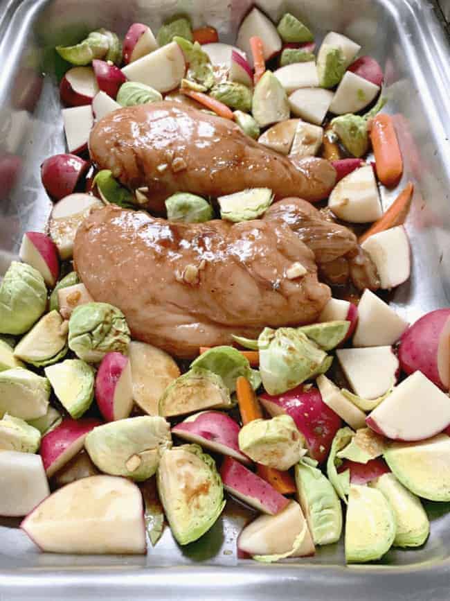 One pan balsamic chicken and roasted vegetables on baking sheet before it's cooked