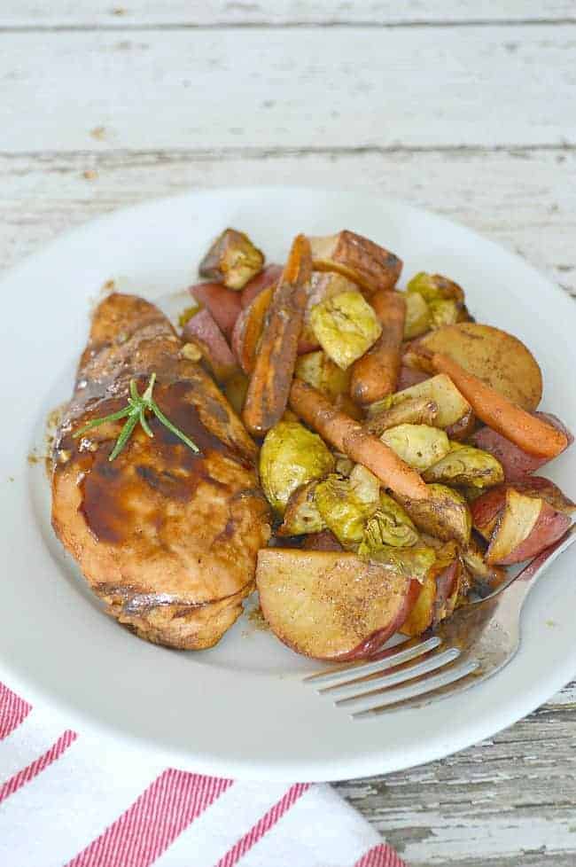 One pan balsamic chicken and roasted vegetables on white plate with red and white napkin