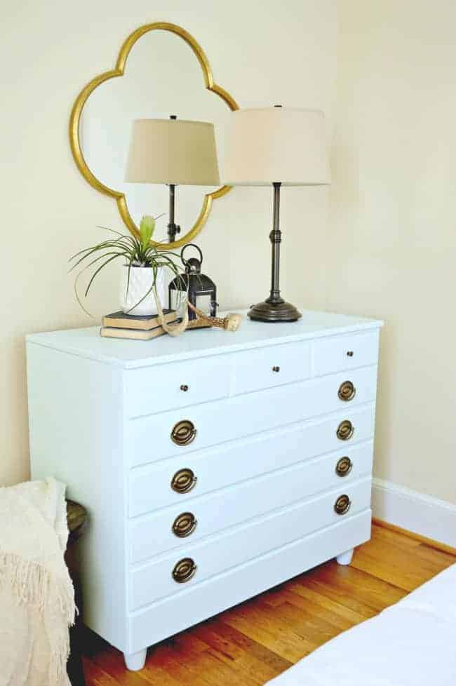 icy blue paint on Goodwill dresser in corner of bedroom with lamp and plants on it