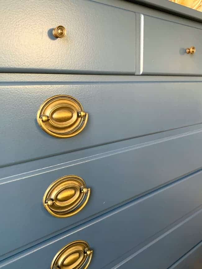 side view of navy dresser with antique brass hardware