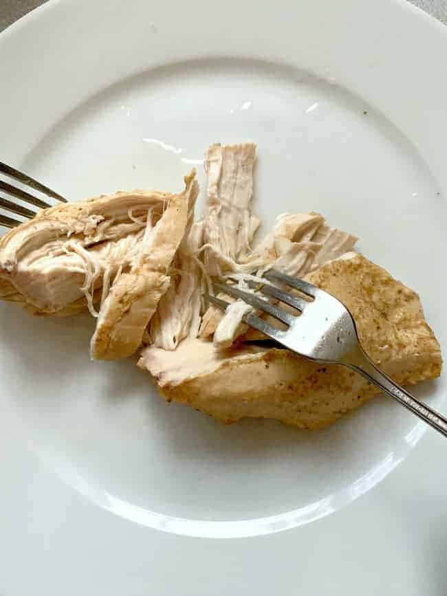 2 forks and shredded chicken breast on a plate