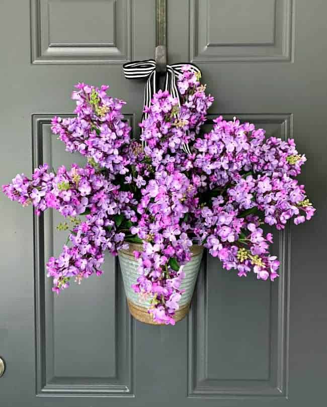 easy DIY spring wreath with lilacs hanging on charcoal painted door