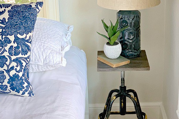 A small nightstand with a lamp and plant