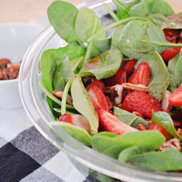 A bowl of salad, with Spinach and Strawberry