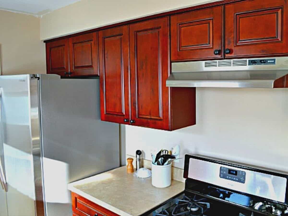 small galley kitchen with dark cabinets and stainless steel stove