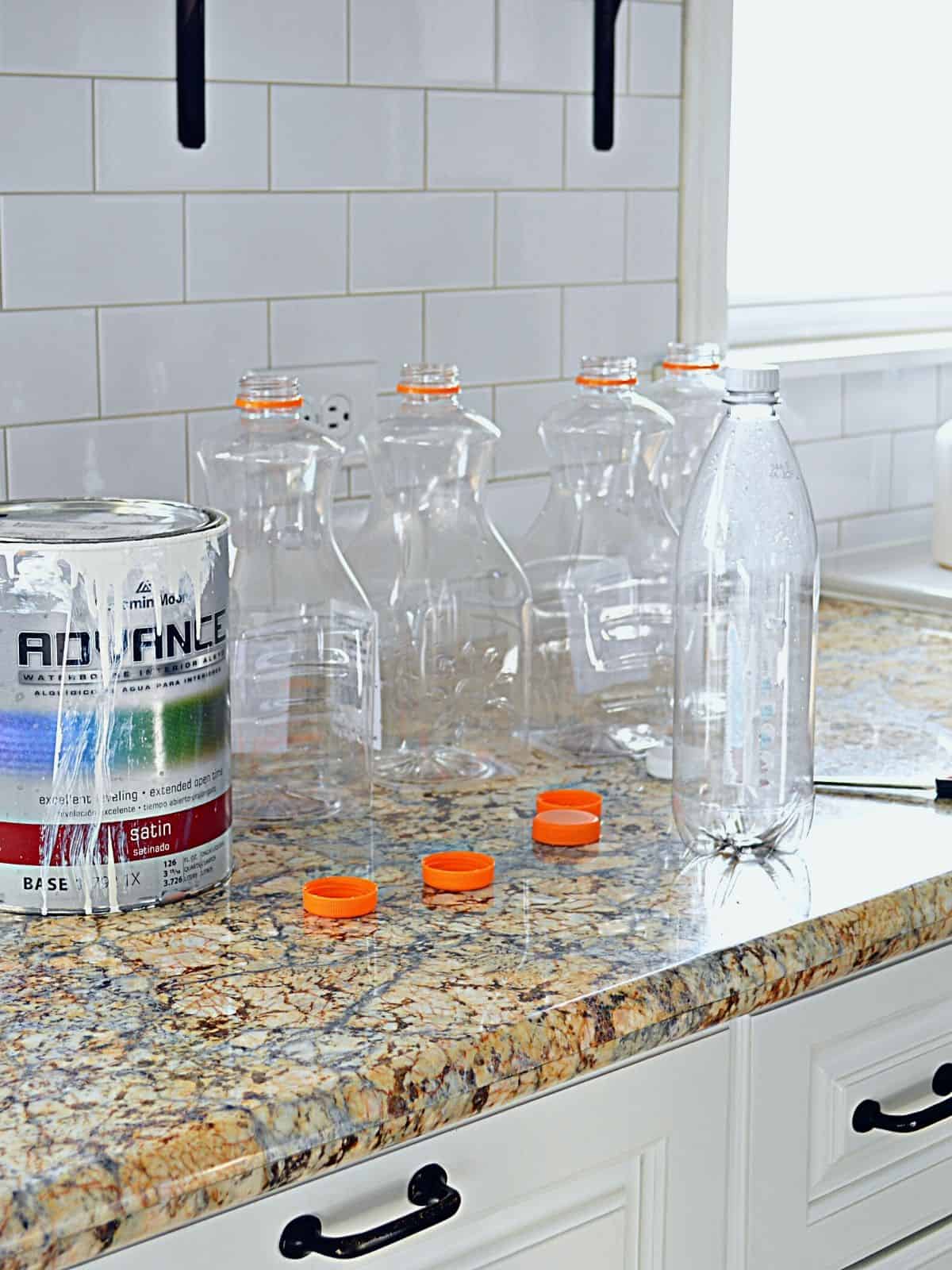 paint can and plastic juice containers on kitchen counter