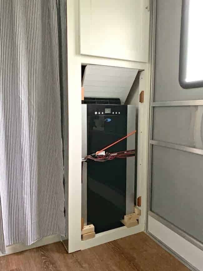 a portable a/c unit built in to a cabinet with straps around it to keep it secure