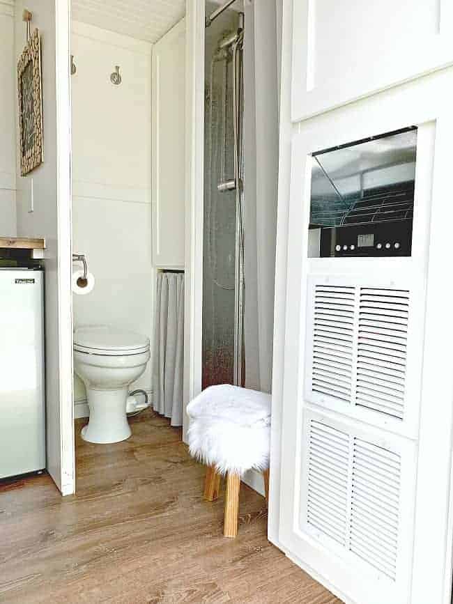 bathroom view of RV toilet, shower and a/c in cargo trailer conversion