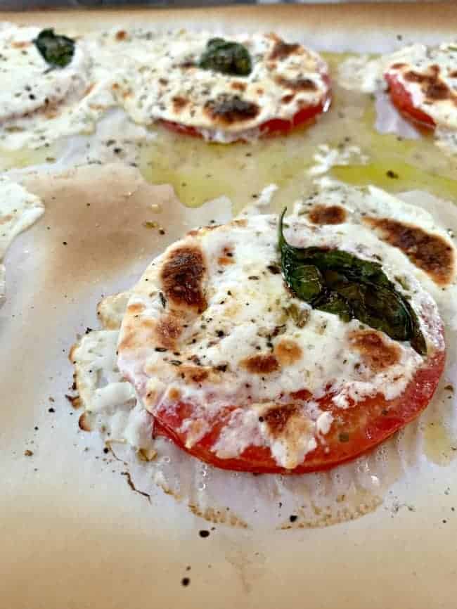 baked tomato and mozzarella slice on parchment lined cookie sheet fresh out of the oven