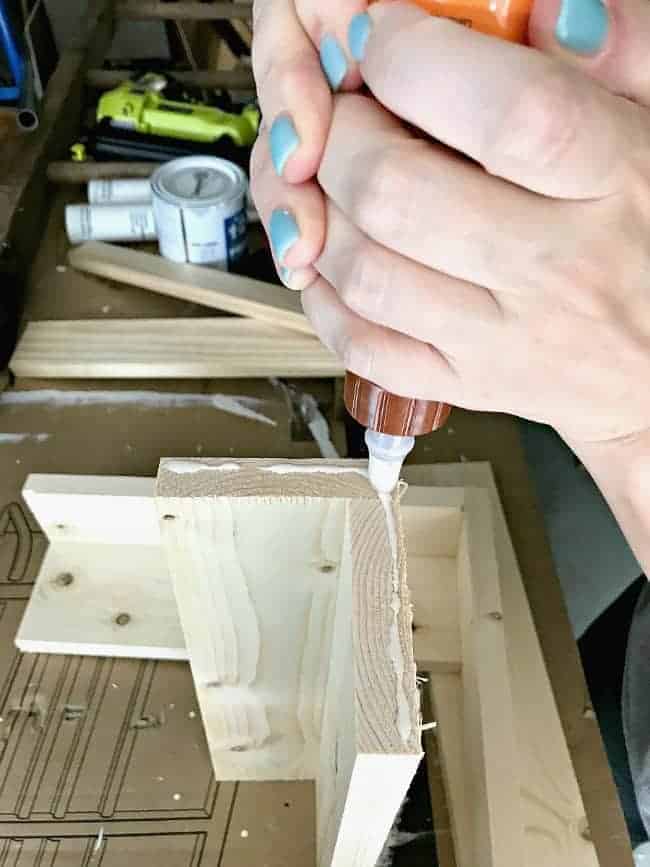 applying wood glue to pine shelf 