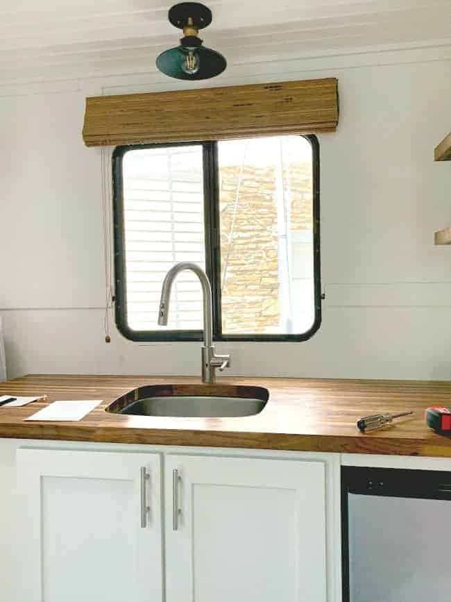 white painted backsplash with butcher block countertop in RV kitchen
