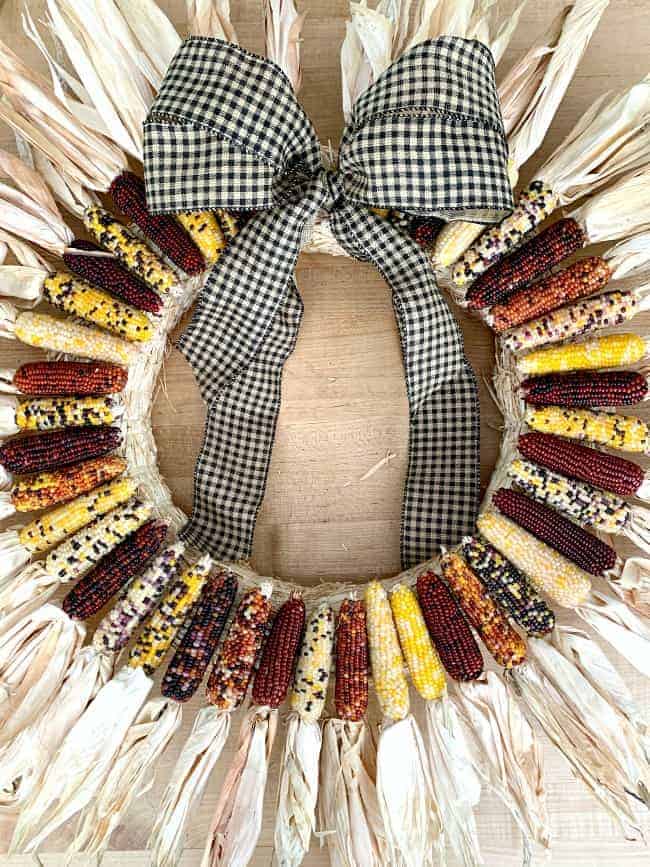 DIY Indian Corn Wreath image mini Indian corn wreath with a large bow laying on a butcher block