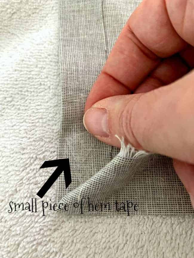 adding a piece of hem tape in angled corner of diy no sew curtain