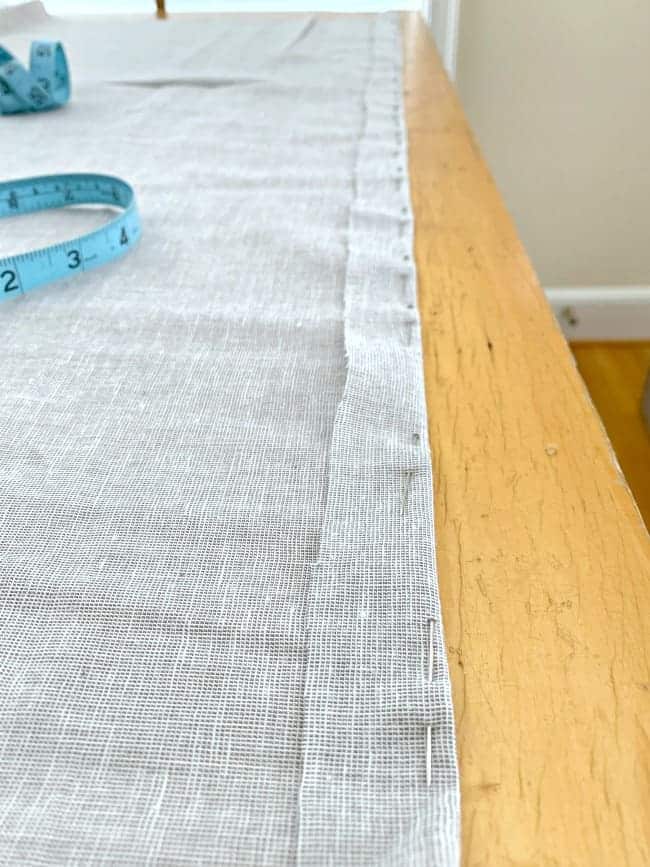 gray fabric on table pinned with a 1" hem