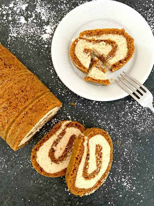 overhead view of pumpkin roll slices on a black cutting board