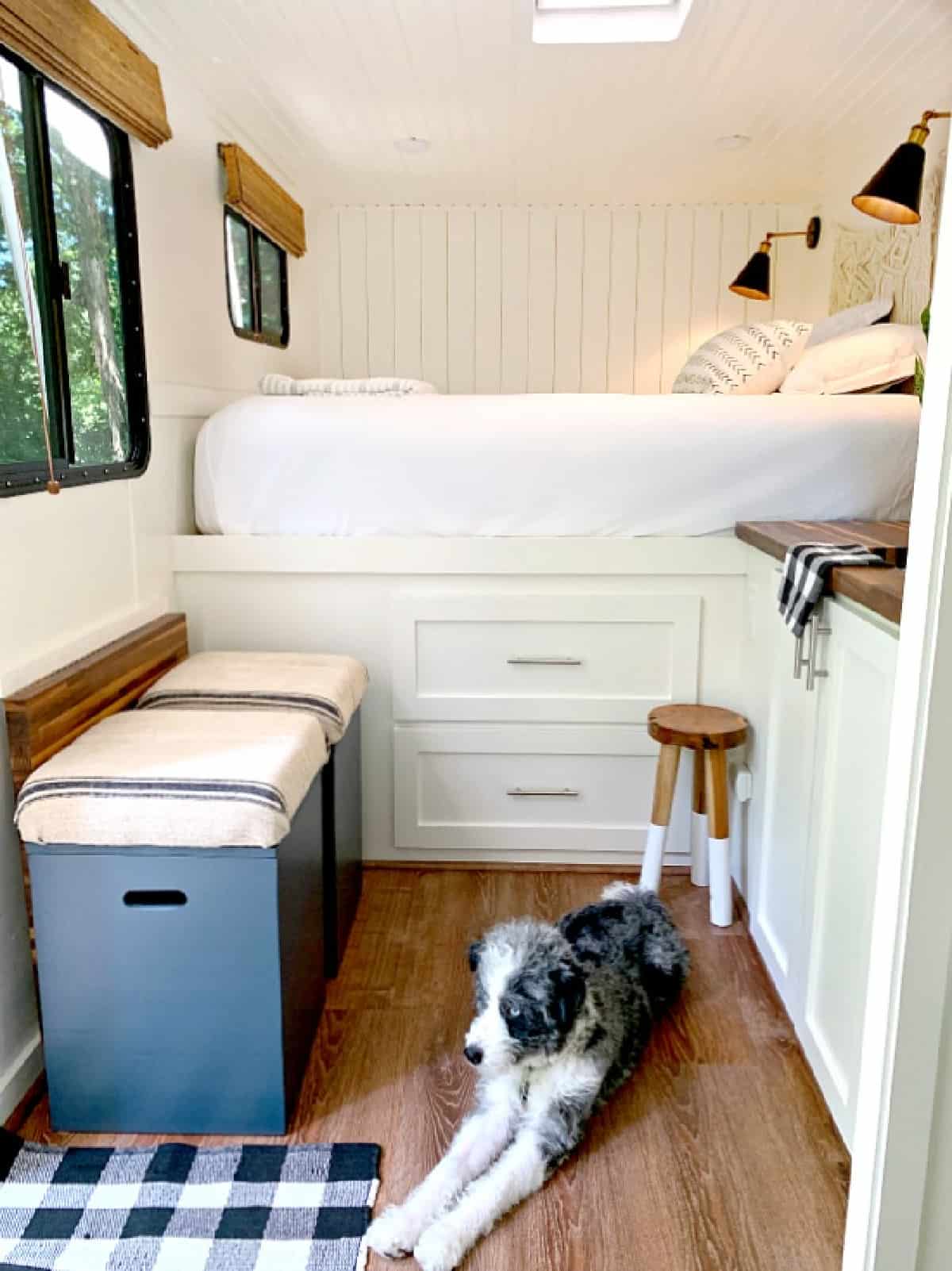 2 navy DIY storage ottomans lined up against wall in RV