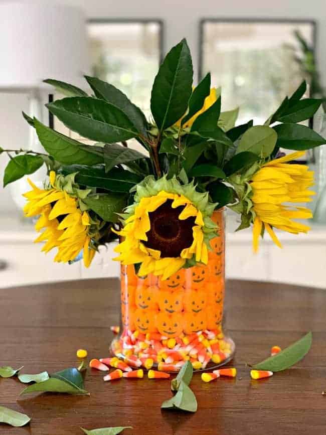 fun fall centerpiece DIY with sunflowers and foliage in the middle of a table