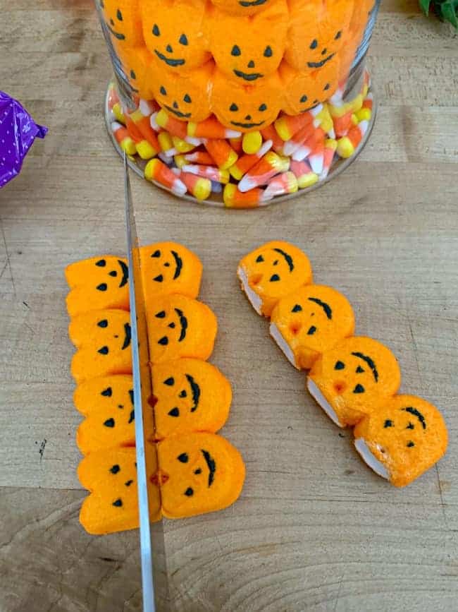 cutting pumpkin marshmallow Peeps with a knife for fall halloween candy centerpiece DIY