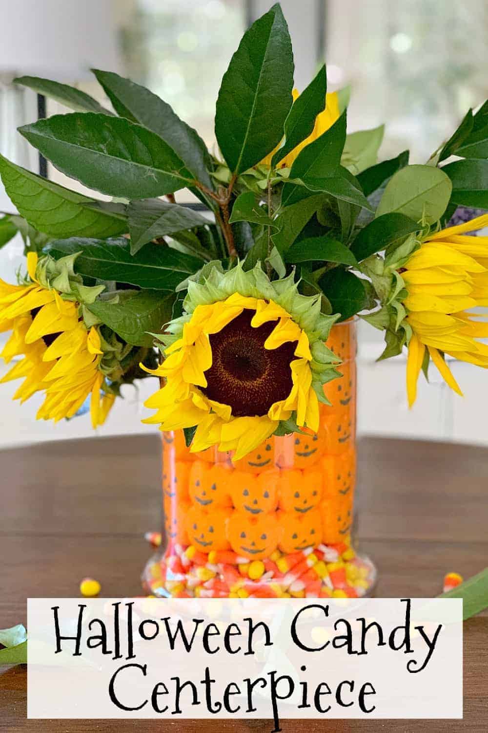 fall candy centerpiece with sunflowers in middle of table