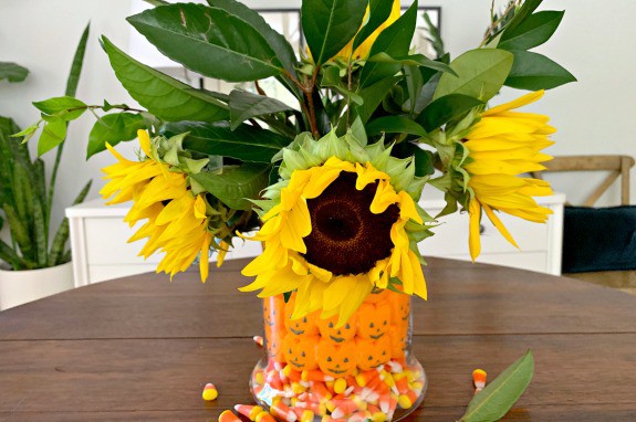 fall candy centerpiece with sunflowers in middle of table