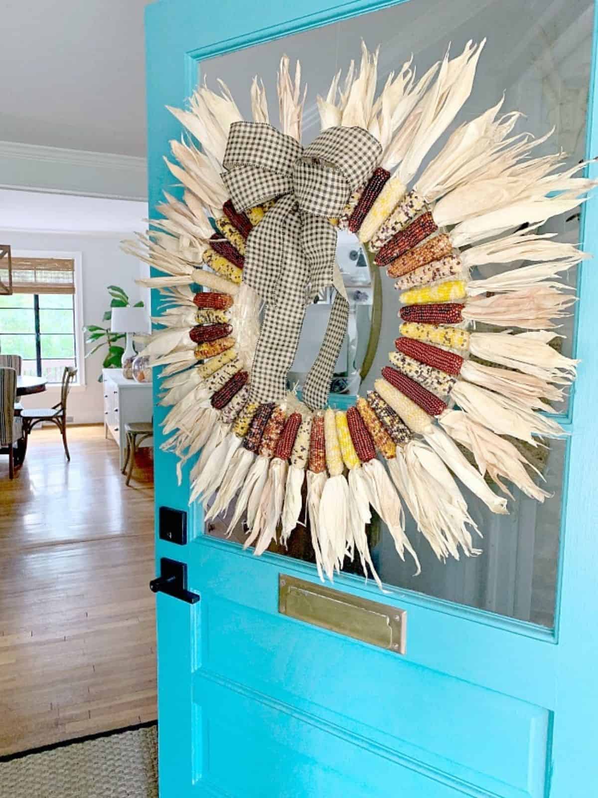 mini Indian corn wreath hanging on turquoise front door