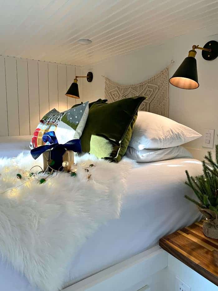 Christmas pillows on bed with faux fur throw