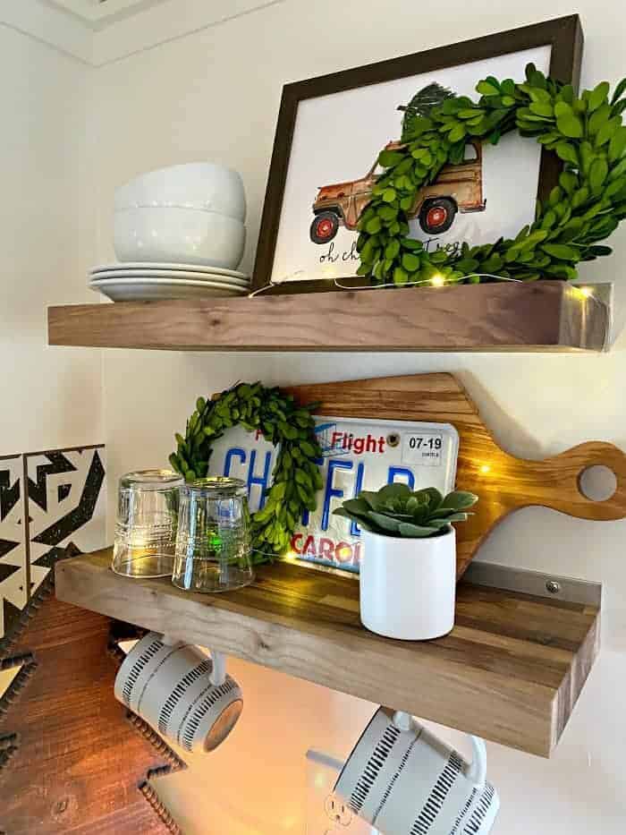 wood shelves in RV decorated for Christmas with wreaths and twinkle lights