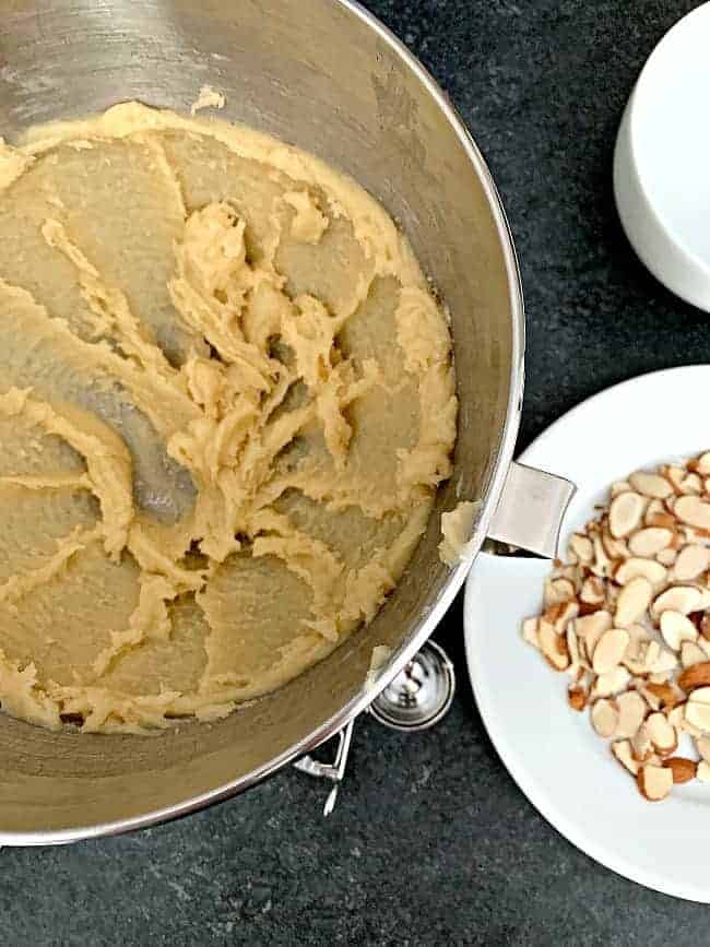 almond horn cookie dough in bowl and sliced almonds on plate